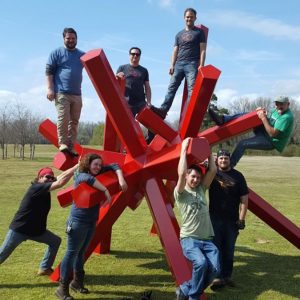 Students, faculty, and a visiting artist Phil Proctor climb on the newest installation of the Yokna Sculpture Trail in Oxford's Lamar Park.