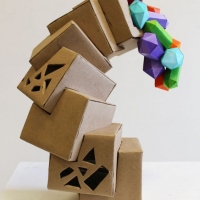 Abstract sculpture of cubes stacked on top of each other and curving upwards.