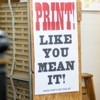Image of a sign that says 'Print like you mean it!'