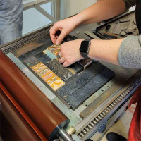 A person handsetting woodtype.